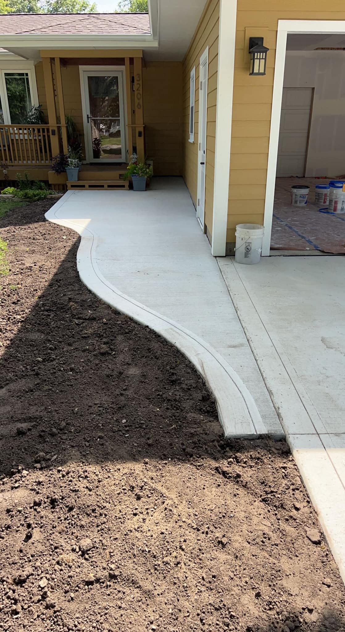 Curved concrete walkway alongside a residential home