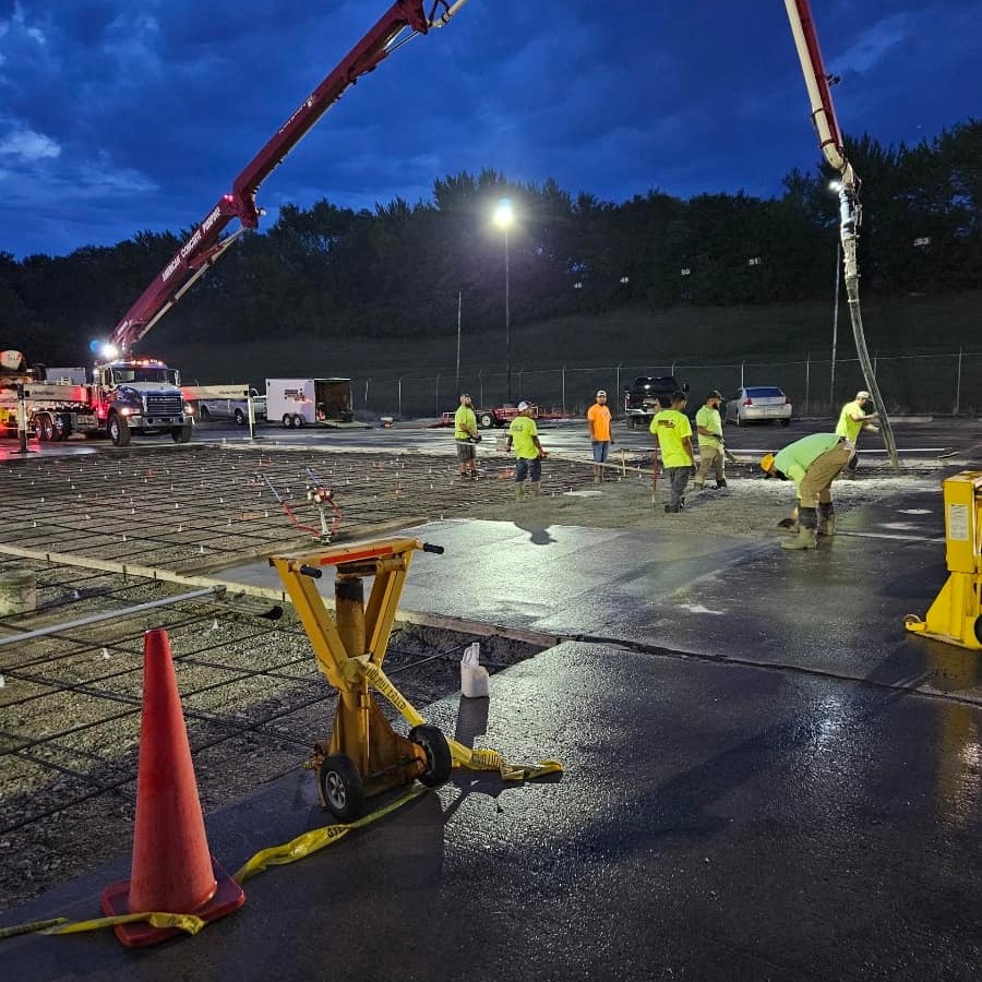 Night-shift commercial parking lot pour with concrete pump truck and crew