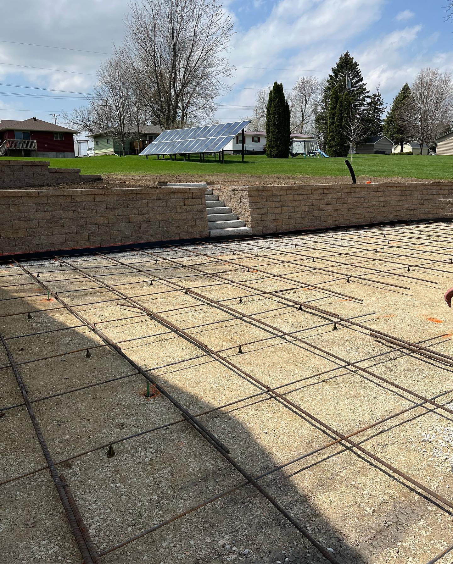 Rebar grid laid out over gravel base, prepped for a pour